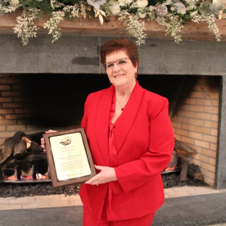 Patty Bomba posing with her Distinguished Citizen of the Year Award